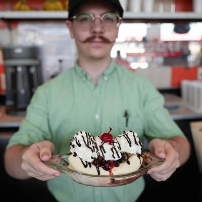 staff member holding banana split.