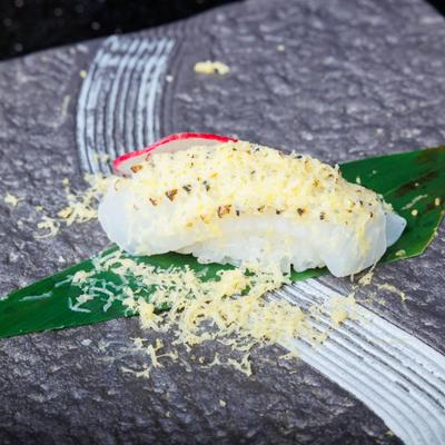 Ika squid nigiri topped with grated cheese.