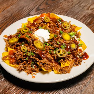 Pulled pork nachos tiopped with jalapenos and sour cream.