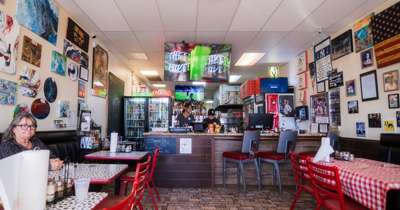 Dining area with a bar and tables with red and white tablecloths