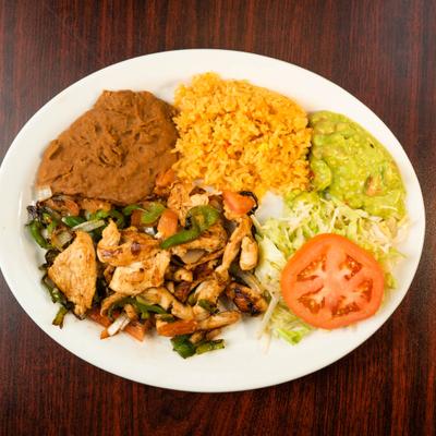 Chicken Fajitas served with rice, refried beans, guacamole and a salad.