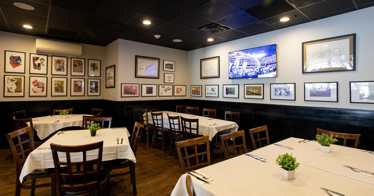 Interior, white cloth tables, tables for four and six people, various framed pictures