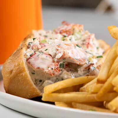 Lobster roll with fries, closeup.