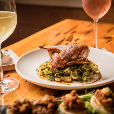 Quail, green salad and glass of white wine on the side
