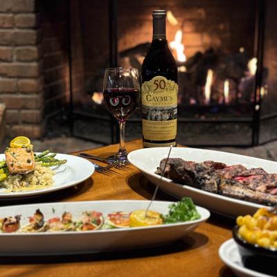 Variety of dishes served on a table with red wine.