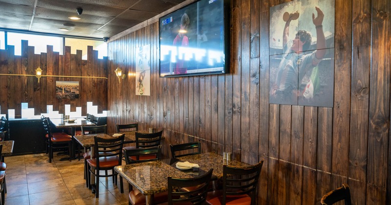 Interior, tables, chairs, wall TV, pictures of footballers, windows, wooden decorum