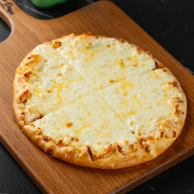 Middle Eastern flatbread topped with cheese on a wooden board.