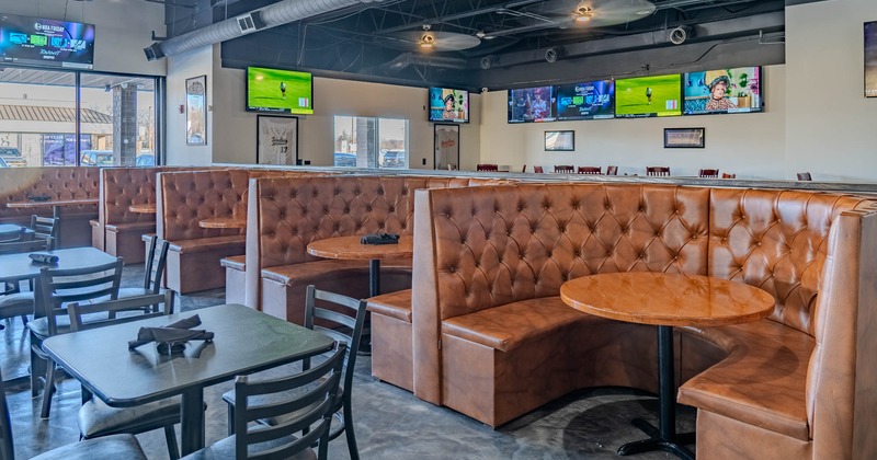 Inside, booths, dining tables, chairs, TVs on the walls