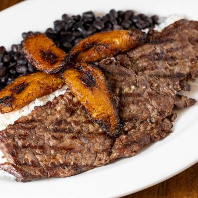 Grilled steak, with fried plantains, rice, and black beans.