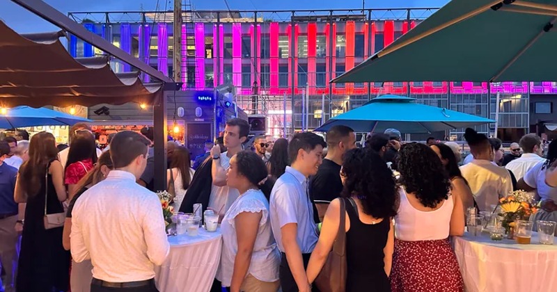 People gathered outdoors in the evening dressed well