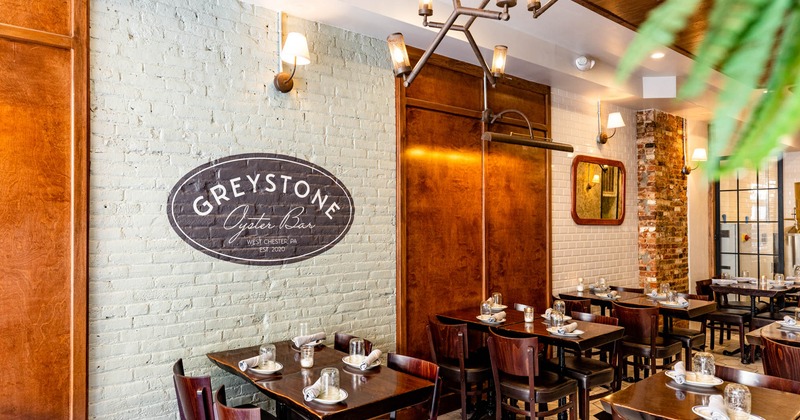 Interior, set dining tables, Greystone logo on a wall