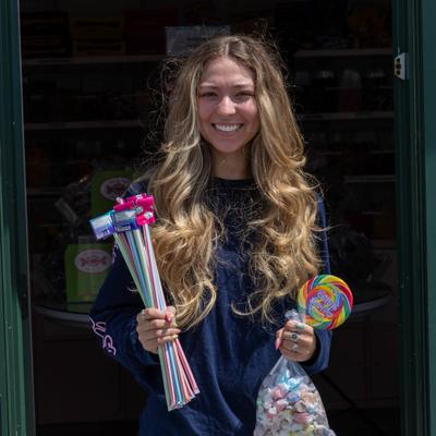 Person holding colorful candy treats outdoors.