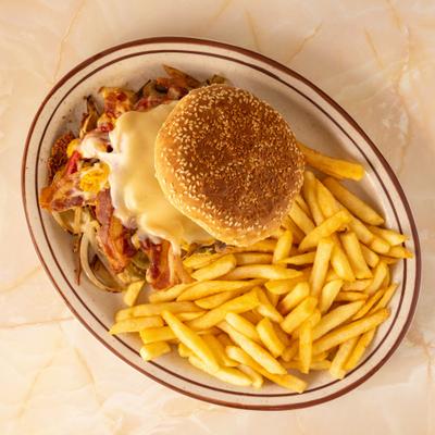 Bacon cheeseburger on a sesame bun, served with a side of French fries.