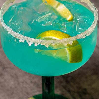 Blue Margarita cocktail with a salted rim and lime garnish.