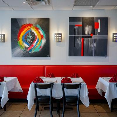 Interior, dining area, set tables, red leather seats, paintings on the wall