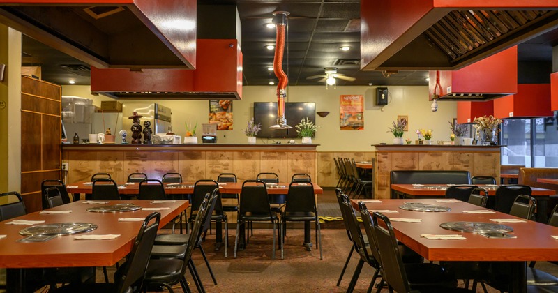 Interior dining area with chairs, tables and tabletop grills