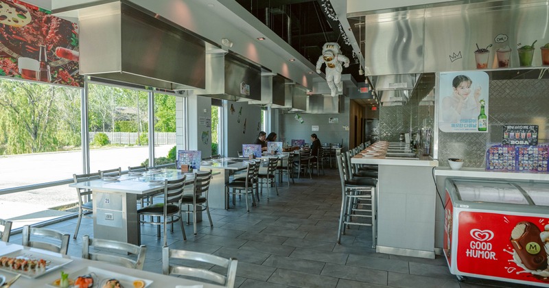 Interior of a modern restaurant with large windows and metal furniture