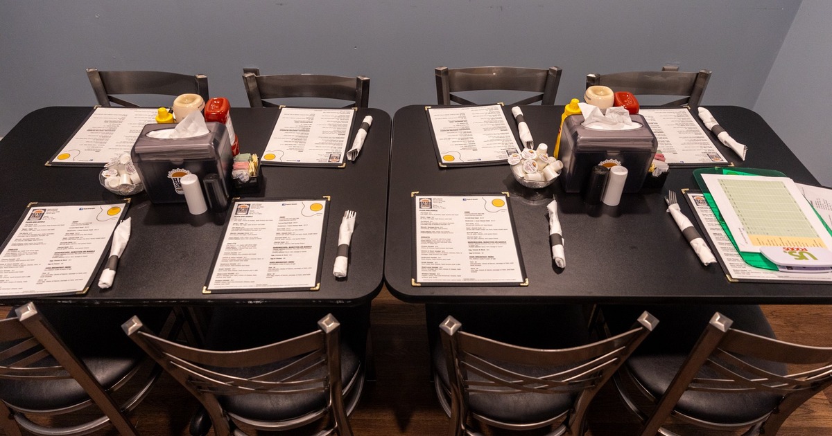 Dining tables with utensils and menus