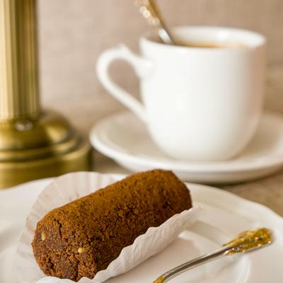 Chocolate cake bar served beside a coffee cup.
