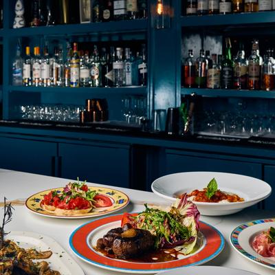 Italian dishes arranged on a table in front of a blue bar.