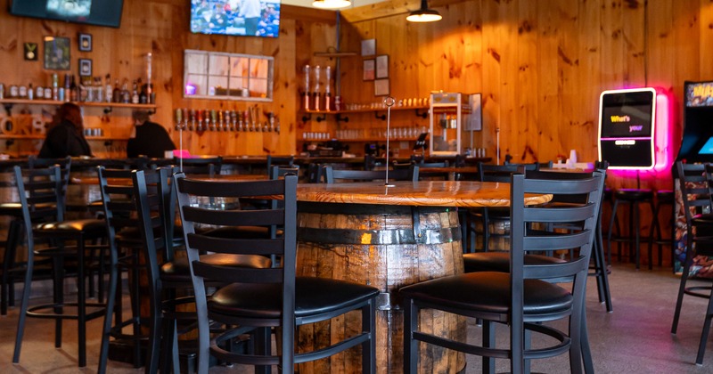 Interior, bar area, barrel tables, stools, bar behind, tv screens