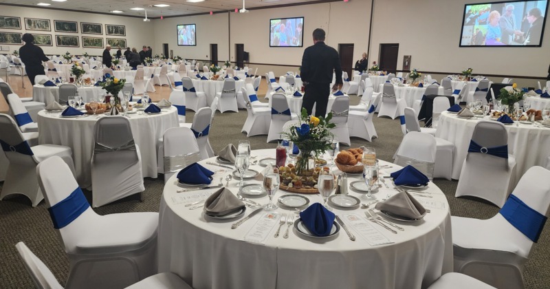 A beautifully arranged banquet hall with tables and chairs ready for dining