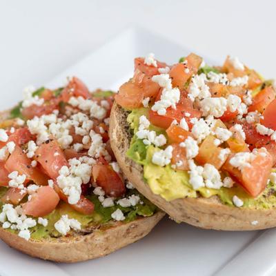 Avocado, tomato and  goat cheese on a toasted honey wheat bagel