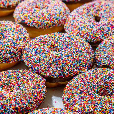 Chocolate frosted donuts with rainbow sprinkles.