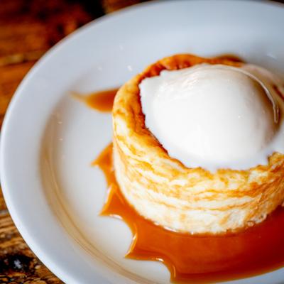 Basque cheesecake with caramel sauce served on a white plate.
