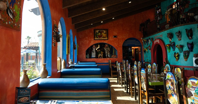 Vibrant restaurant interior with colorful walls, arches, and Mexican masks