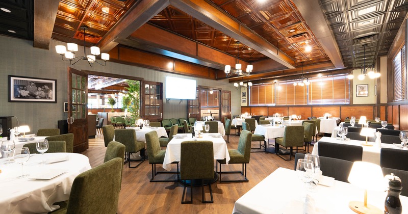 Interior, tables and chairs with tableware, glasses ready for guests