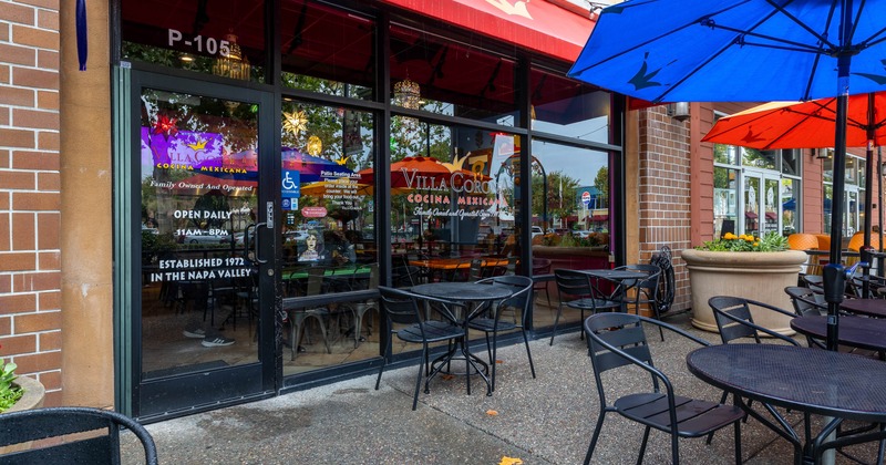 Exterior view of a restaurant with outdoor seating and colorful umbrellas