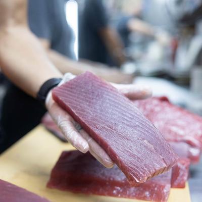 A hand holding a slice of meat.