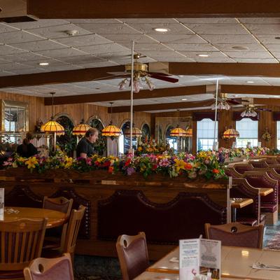 Dining room with floral decorations and pendant lights.