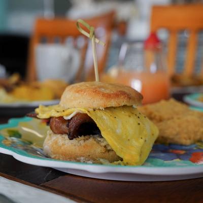 Breakfast sandwich on a biscuit with crispy bacon and egg.