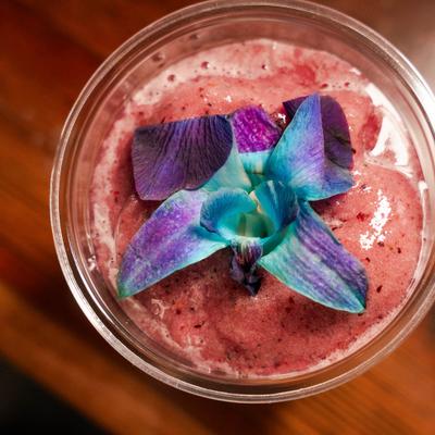 Berry smoothie topped with a flower, top view.