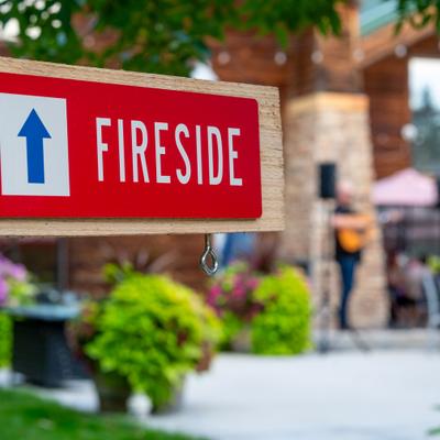 Outdoor red sign reading Fireside with an arrow pointing forward.
