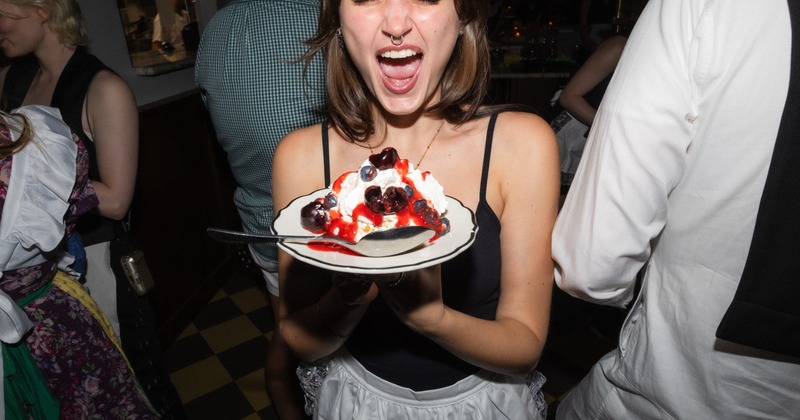 A person holding a dessert plate topped with whipped cream and beerries