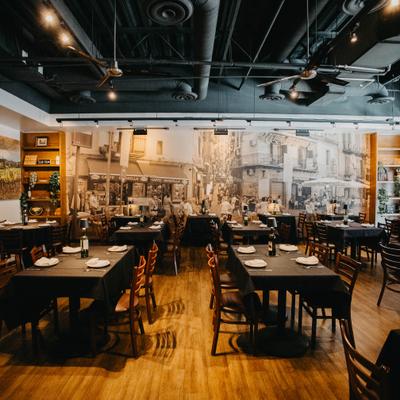 Interior with tables, chairs, a large street scene mural and decorative shelving..