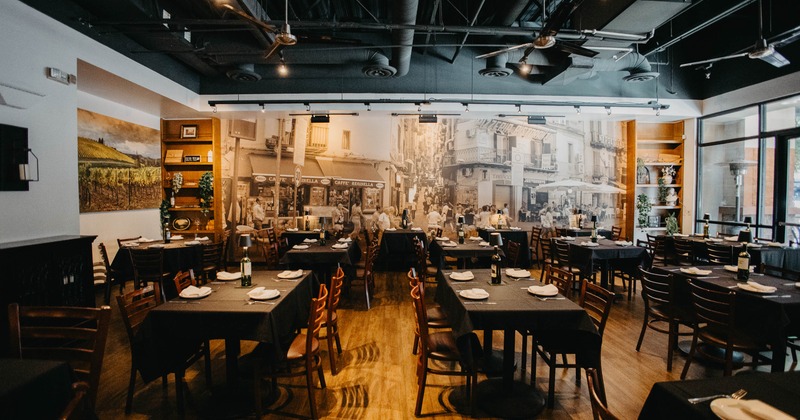 Interior with tables, chairs, a large street scene mural and decorative shelving.
