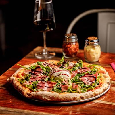 Burrata Prosciutto Figs Pizza paired with red wine.