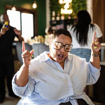 Person dancing and smiling in a bar.
