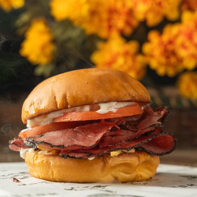 Pastrami Burger with cheese, tomato and sauces.