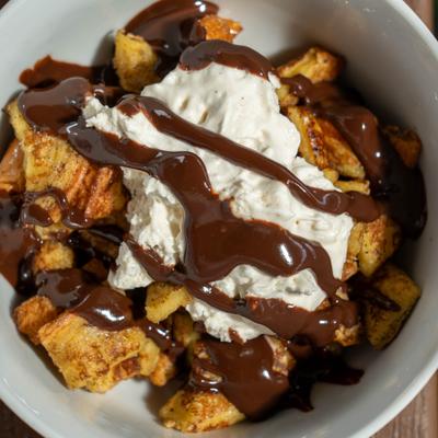 French toast bowl with whipped cream and chocolate sauce.