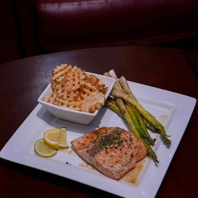 Grilled salmon served with asparagus and waffle fries.