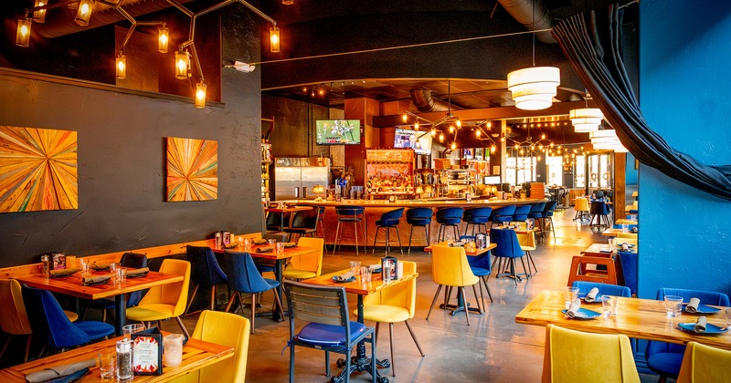 Modern design of the restaurant's dining area with set dining tables and bar area