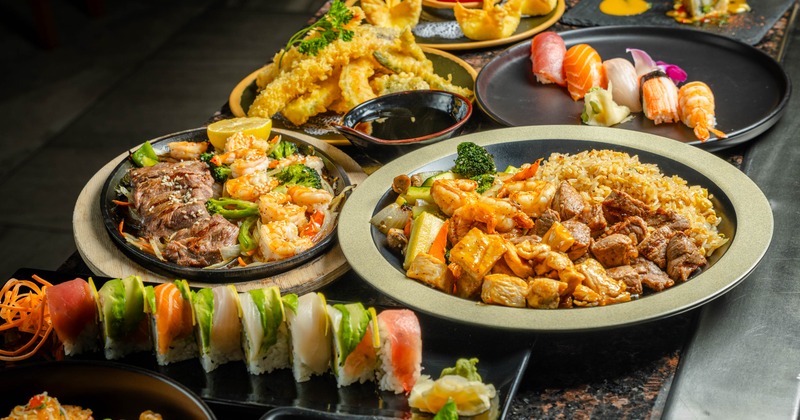 Various dishes and sushi rolls srved on the table