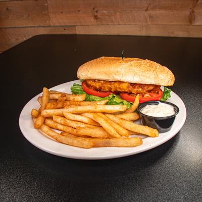 Cod Sandwich with lettuce, tomato, fries and dip on the side.