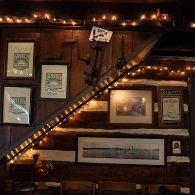 Wood-paneled walls with framed memorabilia, artwork, and a strings of lights.