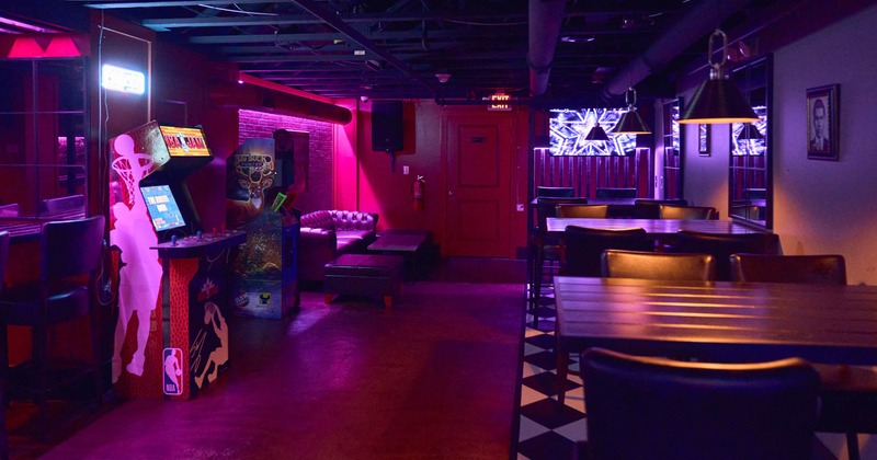 ''Speakeasy'' interior, high seating tables with stools, arcade games, neon lighting